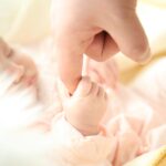 baby holding person s index finger
