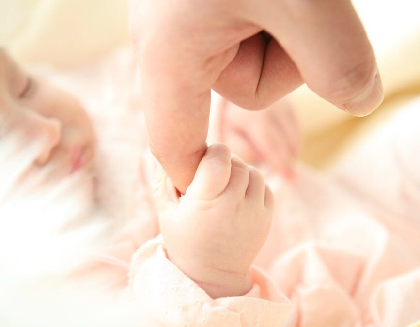 baby holding person s index finger